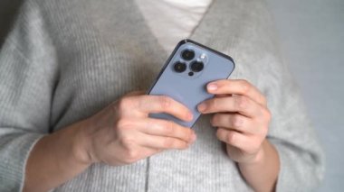 Moskova, Rusya, 10.24.2021 Bir kadın iPhone 13 profesyonel akıllı telefon kullanıyor, parmağını bastırıyor, internetten sosyal ağlar okuyor, daktilo ediyor ve online alışveriş yapıyor. Cep telefonu evde ya da işte.