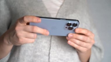 Moskova, Rusya, 10.24.2021 Bir kadın iPhone 13 profesyonel akıllı telefon kullanıyor, parmağını bastırıyor, internetten sosyal ağlar okuyor, daktilo ediyor ve online alışveriş yapıyor. Cep telefonu evde ya da işte.