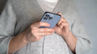 Moskova, Rusya, 10.24.2021 Bir kadın iPhone 13 profesyonel akıllı telefon kullanıyor, parmağını bastırıyor, internetten sosyal ağlar okuyor, daktilo ediyor ve online alışveriş yapıyor. Cep telefonu evde ya da işte.