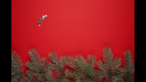 Stop Motion New Year 2022, silver appearing numbers from small stars on a red background with branches of blue spruce — Stock Video