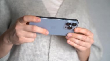 Moskova, Rusya, 10.24.2021 Bir kadın iPhone 13 profesyonel akıllı telefon kullanıyor, parmağını bastırıyor, internetten sosyal ağlar okuyor, daktilo ediyor ve online alışveriş yapıyor. Cep telefonu evde ya da işte.