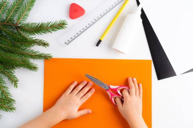 Çocuk Yeni Yıl kaplan maskesi yapma süreci. Renkli kağıttan yapılmış bir çocuk. Üst manzara, sembol 2022, adım 1.