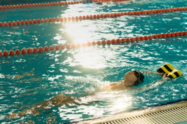 Havuzda yüzen küçük çocuk, çocuk sporları konsepti