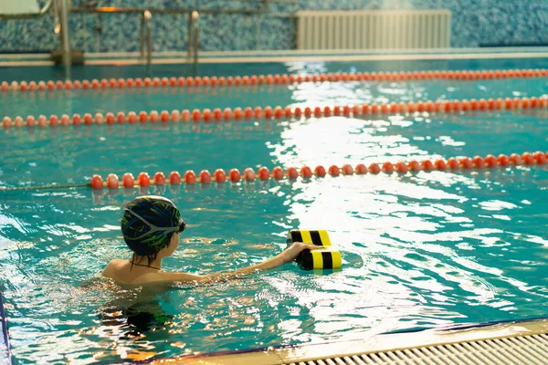 Havuzda yüzen küçük çocuk, çocuk sporları konsepti
