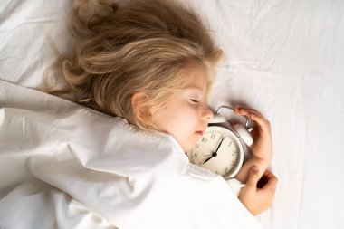 Küçük bir sarışın beyaz iç çamaşırlarıyla yatakta tatlı tatlı uyuyor. Metin için yer aç. Çocuğun sağlıklı uykusu.