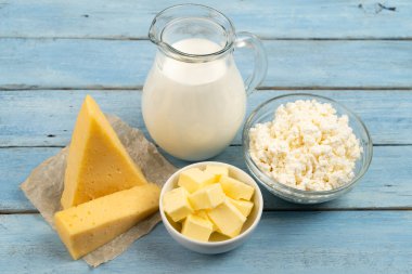 dairy products, cheese, butter, cottage cheese, milk on a blue wooden table