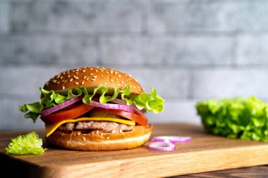 Tahtada hamburgerli, domatesli, peynirli ve marullu.