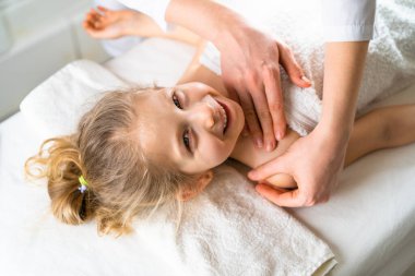 bir kadın küçük bir kıza masaj yapar, çocuk masajı, skolyozu önleme, osteopati