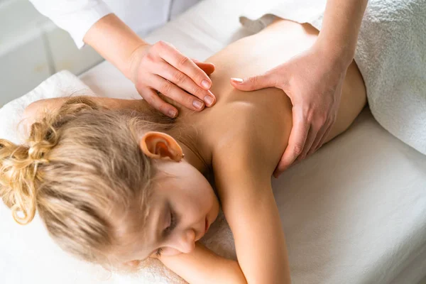 Una mujer da un masaje a una niña, masaje infantil, prevención de escoliosis, osteopatía Fotos De Stock