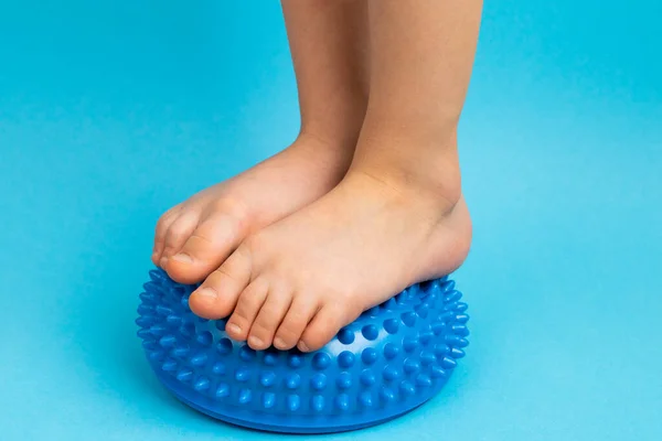 Stopy dziecięce z niebieskim wyważaczem na jasnoniebieskim tle, leczenie i profilaktyka płaskich stóp, deformacja stopy — Zdjęcie stockowe