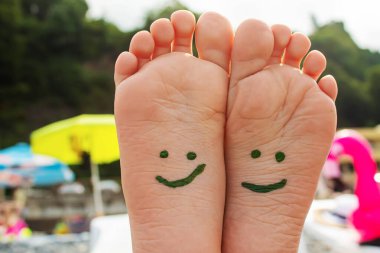 Denizdeki boyalarla boyanmış çocuk ayakları. Seçici odaklanma. Çocuk.