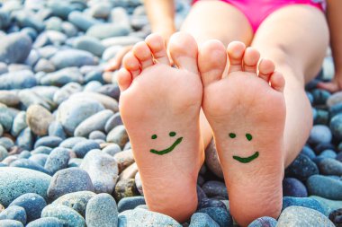 Denizdeki boyalarla boyanmış çocuk ayakları. Seçici odaklanma. Çocuk.