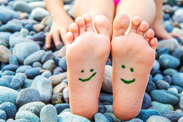 Denizdeki boyalarla boyanmış çocuk ayakları. Seçici odaklanma. Çocuk.