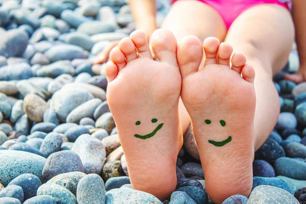 Denizdeki boyalarla boyanmış çocuk ayakları. Seçici odaklanma. Çocuk.