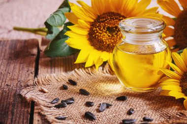 Eski ahşap arka planda ayçekirdeği ve yağ şişesi. Seçici odaklanma. Doğa.