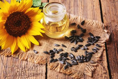 Eski ahşap arka planda ayçekirdeği ve yağ şişesi. Seçici odaklanma. Doğa.