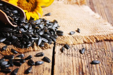 Eski ahşap arka planda ayçekirdeği ve yağ şişesi. Seçici odaklanma. Doğa.