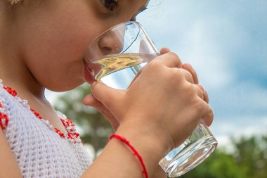 Çocuk doğal olarak saf su içiyor. Seçici fokus. Çocuk.