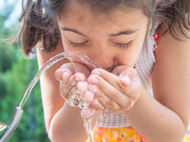 Çocuk doğal olarak saf su içiyor. Seçici fokus. Çocuk.