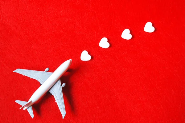 Hati dan pesawat dengan latar belakang merah. Hari Valentine. Fokus selektif. — Stok Foto