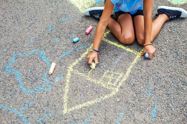 Çocuklar kaldırıma Ukrayna bayrak evini çiziyor. Seçici odaklanma. Çocuk.