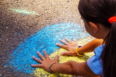 Çocuklar asfalta bir gökkuşağı çizerler. Seçici odaklanma. Çocuklar.