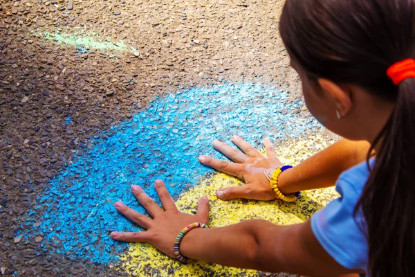 Çocuklar asfalta bir gökkuşağı çizerler. Seçici odaklanma. Çocuklar.