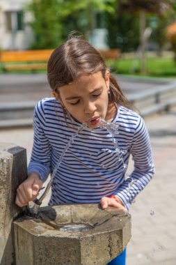 Çocuklar pınardan su içer. Seçici odaklanma. Doğa.