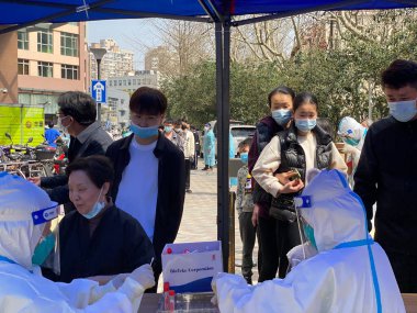 Şangay, Çin - 17 Mart 2022: Çin 'in en kalabalık şehirlerinden biri olan Şangay' da çok sayıda olumlu vaka ortaya çıktıktan sonra bir Topluluk Test Merkezi 'nde CVID testi kuyruğunda bekleyenler.
