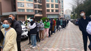 Şangay, Çin - 18 Mart 2022: Çin 'in en kalabalık şehirlerinden biri olan Şangay' da çok sayıda olumlu vaka ortaya çıktıktan sonra bir Topluluk Test Merkezi 'nde CVID testi kuyruğunda bekleyenler.