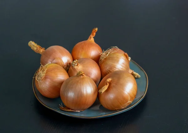 Onion Bulbs Plate Black Wooden Background — Zdjęcie stockowe