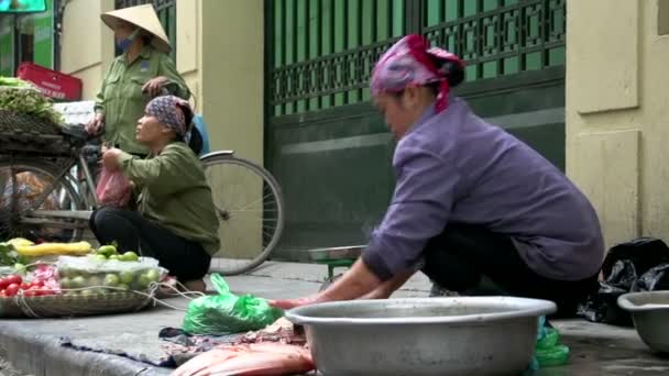 Frau schneidet Fisch auf einem Wochenmarkt — Stockvideo