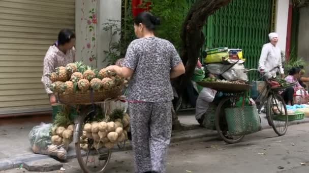 Kobieta podchodzi do dziewczyny, która sprzedaje ananas z jej rower — Wideo stockowe