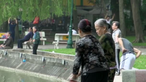Menschen, die am Ufer des Hoan-Kiem-Sees trainieren — Stockvideo