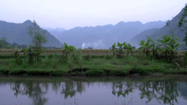 Горы и сельскохозяйственные угодья с отражением в озере — стоковое видео