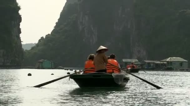 Turistas en un barco navegando por un pueblo pesquero — Vídeo de stock