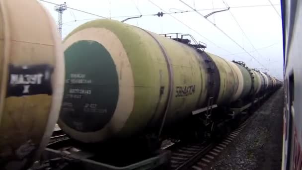 Поезд проезжает мимо станции с нефтеналивными контейнерами в России — стоковое видео