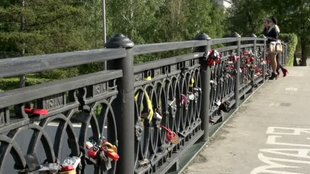 Puente en Irkutsk con cerraduras de amor y para las niñas en el fondo — Vídeo de stock