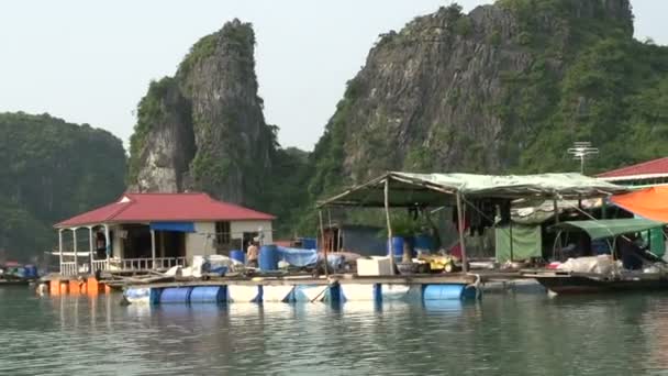 Zeilen door zwevende vissersdorp in ha long baai — Stockvideo