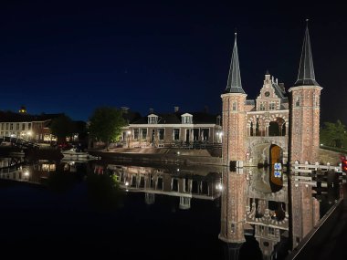 Hollanda, Friesland, Sneek 'teki Waterpoort' un gece kanalı yansıması.