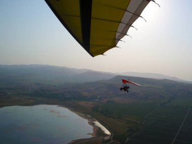 Başka bir planörden uçan bir motorlu planörün fotoğrafı.