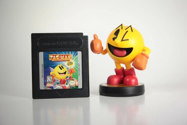 New York, New York - 10 Ekim 2021: Namco Pac-man video oyunu ürünleri. Amiibo Switch figürlü klasik Nintendo Gameboy kartuşu