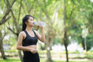 Spor kadınları bahçede koştuktan sonra su içiyorlar.
