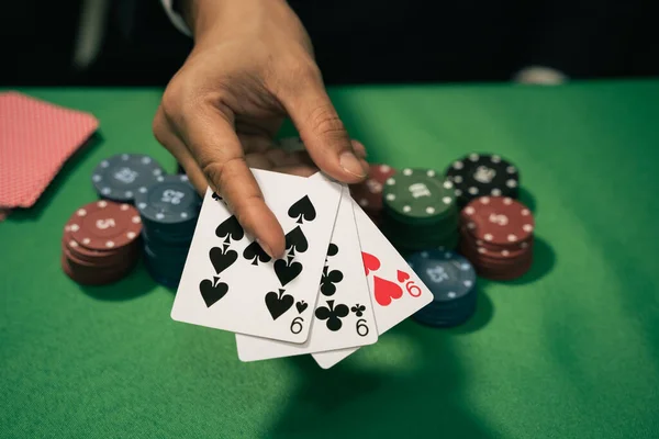 Man dealer or croupier shuffles poker cards in a casino game card, and chips on green table. poker game concept