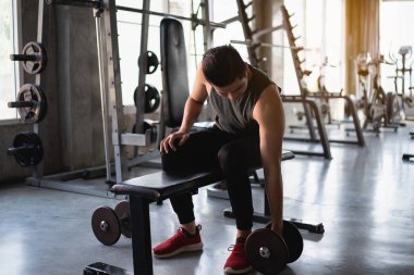 Spor salonundaki ağırlık odasında çalışan Asyalı formda bir sporcu. Spor adamı konsepti