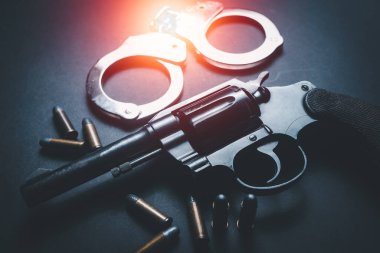 Silahlar, mühimmat ve prangalar karanlık bir masaya, kısa silahlar, mühimmat ve prangalar siyah bir arka plan masasına, silahlar ve mühimmat kullanılmaya hazır. Gürültülü silah