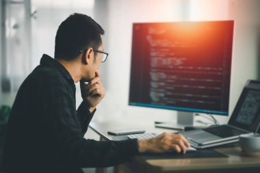 Ofiste dizüstü bilgisayarda çalışan bir yazılım mühendisi. Çalışan programcı web uygulaması geliştirir. Yazılım programlama kavramı