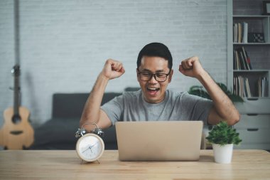 Gözlüklü serbest çalışan, dizüstü bilgisayarla çalışan neşeli, ahşap masada oturan. Sosyal ağda iletişim kuran mutlu adam, konferans vdo çağrısı.