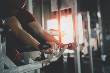Spor adamı spor salonunda dambıl egzersizi yapıyor. Kas eğitimi için Asyalı vücut geliştirme. Spor konsepti