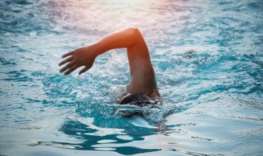 Spor adamı yüzücü triatlon fitness sporcusu spor salonunda havuzda yüzme eğitimi alıyor. Yüzücü adam mavi su pankartıyla yüzüyor. Spor ve spor kardiyo egzersizi..
